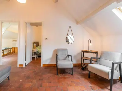 a living room with two chairs and a mirror at Nice apartment on UNESCO World Heritage Site Wortel-Kolonie in Staakheuvel