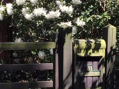 a fence with a sign on it next to a bench at Gierle Garden Bungalow Escape in Lille