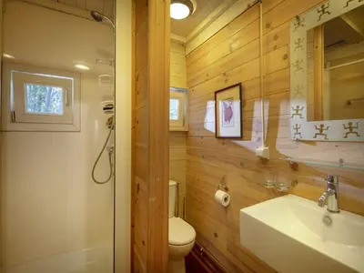 a bathroom with wooden walls and a sink and a toilet at Gierle Garden Bungalow Escape in Lille