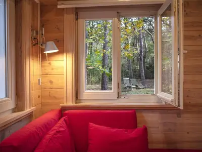 a red couch in a room with a window at Gierle Garden Bungalow Escape in Lille