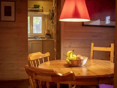 a kitchen with a wooden table with a bowl of fruit at Gierle Garden Bungalow Escape in Lille