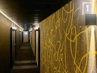 a hallway with yellow graffiti on a wall at OccO in Willebroek