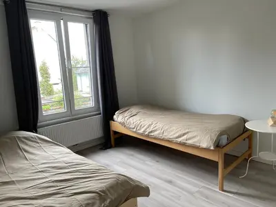 a bedroom with two beds and a window at House between Antwerp and Brussels in Rumst