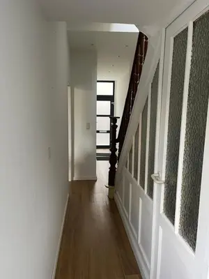 a hallway with white walls and wood floors and a staircase at House between Antwerp and Brussels in Rumst