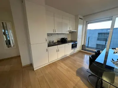 a kitchen with white cabinets and a large window at Apartment with Stunning View in City Center in Brussels