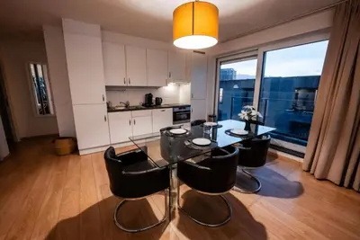 a dining room with a table and chairs and a kitchen at Apartment with Stunning View in City Center in Brussels
