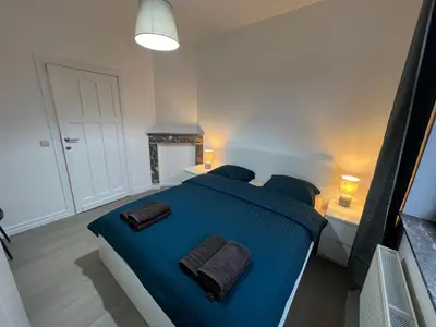 a bedroom with a large blue bed with two pillows at Cosy Apartment Merode 2 in Brussels