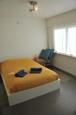 a bedroom with a bed with two blue towels on it at at Number 1 in Rumst