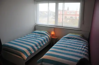 two beds in a small room with a window at at Number 1 in Rumst