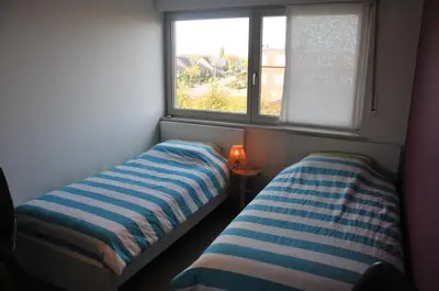 two beds in a small room with a window at at Number 1 in Rumst
