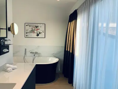 a bathroom with a bath tub and a sink at Comic Art Hotel in Ghent