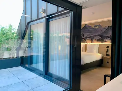 a room with sliding glass doors leading to a bedroom at Comic Art Hotel in Ghent