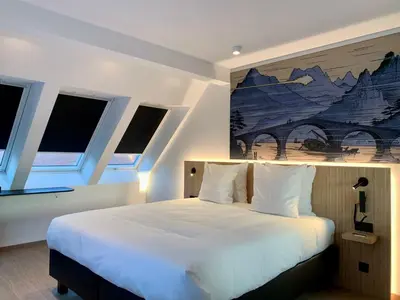 a bedroom with a white bed with a painting on the wall at Comic Art Hotel in Ghent