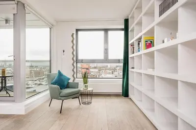 a living room with a chair and a window at London Tower Apartments - Antwerp in Antwerp