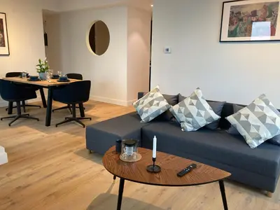 a living room with a blue couch and a table at London Tower Apartments - Antwerp in Antwerp