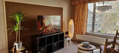 a living room with a flat screen tv on a wall at SUPERB FLAT WITH 3 BEDROOMS PARKING AND BALCONy in Antwerp