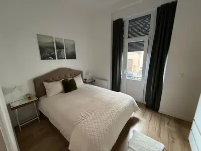 a bedroom with a bed and a large window at Cozy South-Up and Ground in Brussels