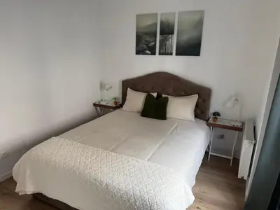 a bedroom with a large white bed with two night stands at Cozy South-Up and Ground in Brussels