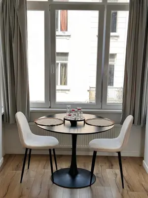 a table and two chairs in a room with windows at Cozy South-Up and Ground in Brussels