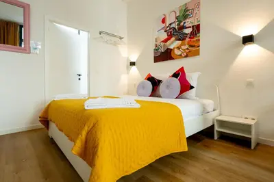 a bedroom with a bed with a yellow blanket at Miniloft Pelgrim in Antwerp