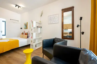 a bedroom with a bed and a couch and a chair at Miniloft Pelgrim in Antwerp