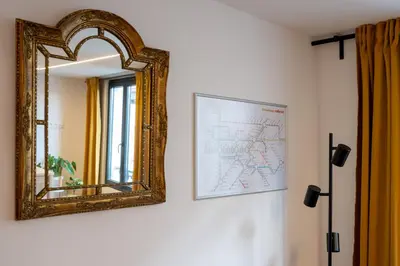 an ornate mirror on a wall with a picture at Miniloft Pelgrim in Antwerp