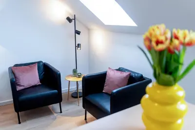 a room with two chairs and a vase with flowers at Miniloft Pelgrim in Antwerp