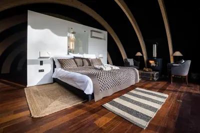 a bedroom with a large bed and a rug at Room8 luxury glamping in Huldenberg
