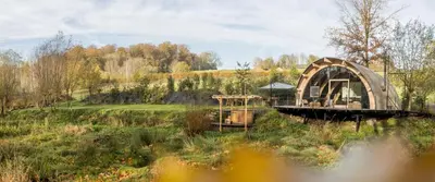 an old building in the middle of a field at Room8 luxury glamping in Huldenberg