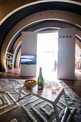 a living room with a table and a bottle of wine at Room8 luxury glamping in Huldenberg