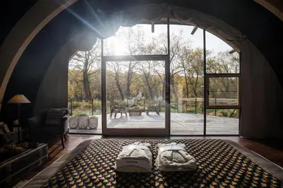 a room with two beds in a room with a large window at Room8 luxury glamping in Huldenberg