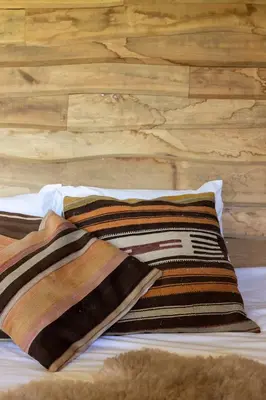 a bed with two pillows on top of it at Cabin Margot with hot tub in private garden in Kaprijke