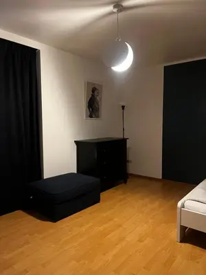 a living room with a bed and a black couch at Apartment 202 in Ghent