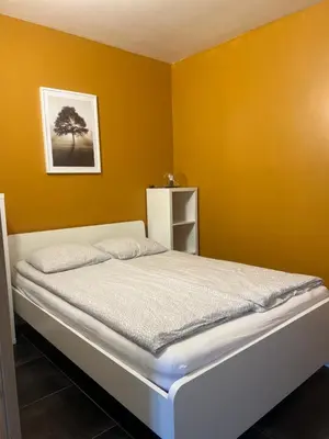 a bedroom with a bed in a yellow wall at Apartment 202 in Ghent
