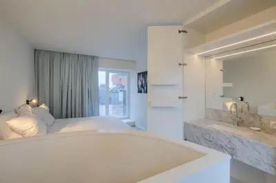 a white bedroom with a bed and a sink at ANCHOR LODGE ANTWERP Unique Appartment view MAS! in Antwerp