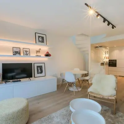 a living room with a television and a table and chairs at ANCHOR LODGE ANTWERP Unique Appartment view MAS! in Antwerp