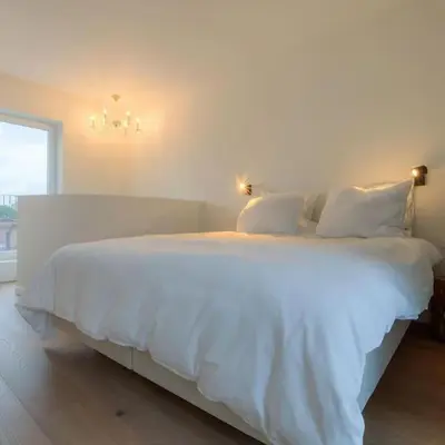 a white bed with white sheets and pillows in a bedroom at ANCHOR LODGE ANTWERP Unique Appartment view MAS! in Antwerp