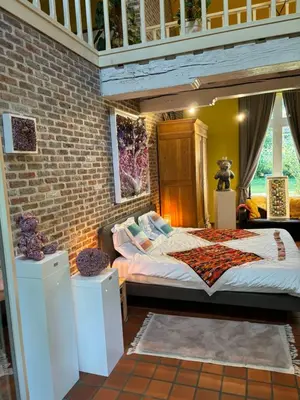 a bedroom with a large bed in a brick wall at Karibu Keerbergen in Keerbergen