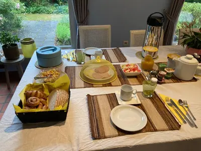 a table with food and plates on top of it at Karibu Keerbergen in Keerbergen