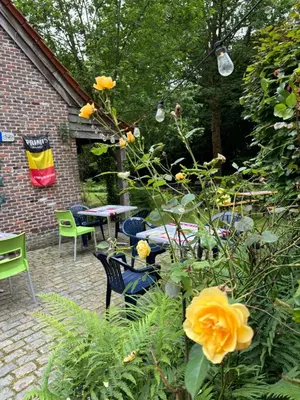 a garden with a table and chairs and flowers at Karibu Keerbergen in Keerbergen
