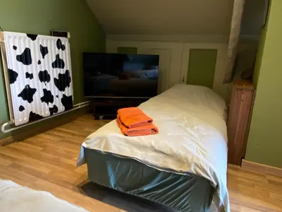 a bedroom with a bed with an orange towel on it at CasaDeKaMa in Evergem