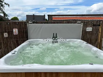 a hot tub with two bottles of wine in it at CasaDeKaMa in Evergem