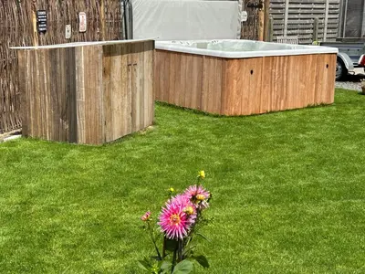 a garden with a hot tub and a flower at CasaDeKaMa in Evergem