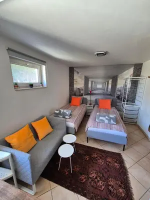 a living room with a couch and a bed at Studio équipé Brussels in Sint-Pieters-Leeuw