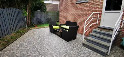 two black chairs sitting on a patio next to a building at Studio équipé Brussels in Sint-Pieters-Leeuw