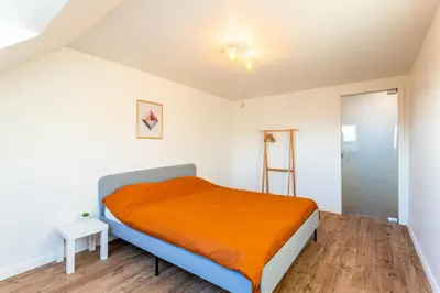 a bedroom with a bed with an orange blanket at Loft Gent in Ghent