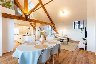 a kitchen and living room with a table and chairs at Loft Gent in Ghent