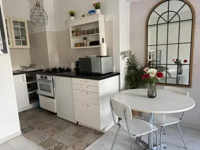 a kitchen with a white table and a white table and a table at Lovely condo next to European Area in Brussels