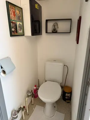 a small bathroom with a toilet and pictures on the wall at Lovely condo next to European Area in Brussels