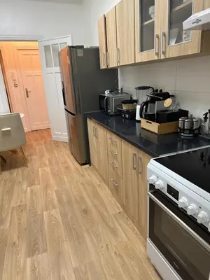 a kitchen with wooden cabinets and black counter tops at Appartement 2 chambre luxueuse à jette in Brussels